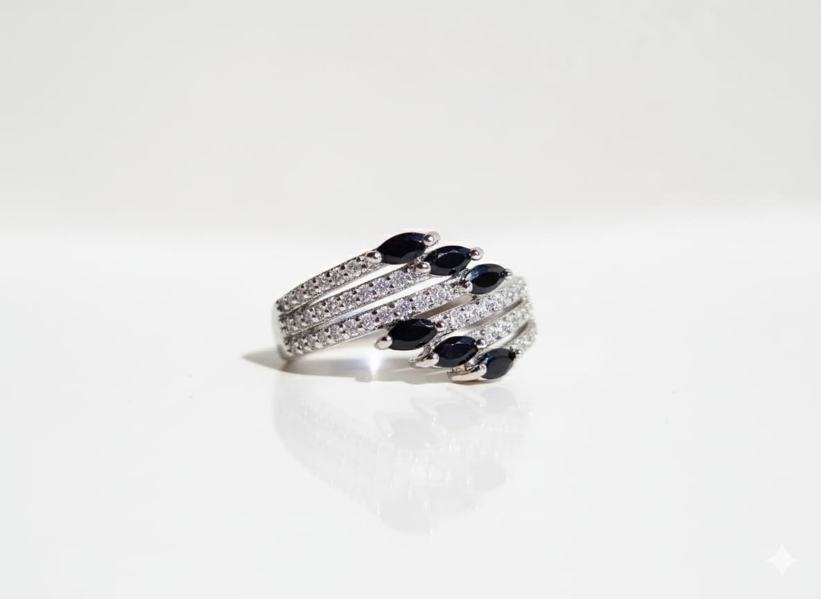 Silver ring with black gemstones on a white background